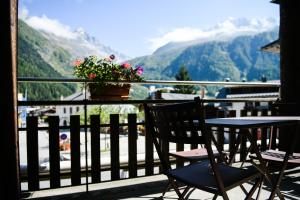 a table and chairs on a balcony with a view of mountains at Le Dahu in Chamonix