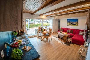 a living room with a red couch and a table at Haus Erli in Mittenwald