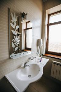 La salle de bains est pourvue d'un lavabo blanc et d'un miroir. dans l'établissement Карпаты, à Khoust