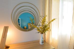 un jarrón sentado en una mesa frente a un espejo en Margarita's Seafront Luxury Apartment en Elounda