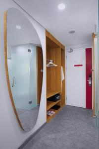 a bathroom with a mirror and a walk in shower at favehotel Ketapang in Ketapang