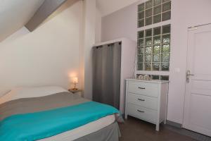 um quarto com uma cama, uma cómoda e uma janela em GITE LES ROCHES em Moigny