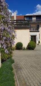 einen Busch mit lila Blumen neben einem Gebäude in der Unterkunft Bed & Breakfast Hotel Müllerhof in Caputh