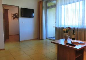 a room with a table with a vase of flowers on it at KARL Haus KMB Seeappartement am Ossiacher See mit direktem Seezugang, Hallenbad in Bodensdorf