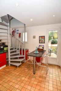 cocina con mesa y escalera de caracol en GITE LES ROCHES, en Moigny