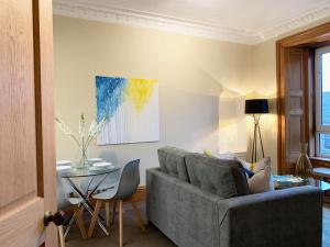 un soggiorno con divano e tavolo di Forest Park Apartment a Dundee