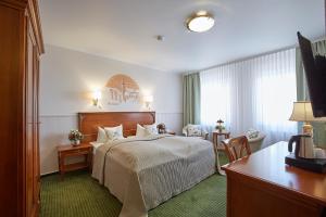 a hotel room with a bed and a desk at Hotel Beek by Anna in Baden-Baden