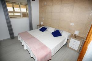 een slaapkamer met een groot bed met blauwe kussens bij Ático Manzanera Calpe in Calpe +24 foto's