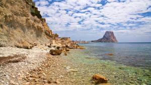 een rotsachtig strand met een berg in het water bij Ático Manzanera Calpe in Calpe
