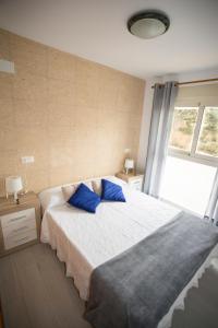 een slaapkamer met een groot bed met blauwe kussens bij Ático Manzanera Calpe in Calpe