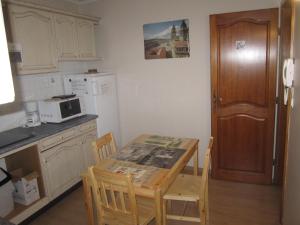 a kitchen with a table and chairs and a microwave at Gîte La Bastide in Tournon-dʼAgenais