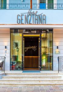 uma frente de loja com um sinal na porta em Hotel Genziana em Ortisei
