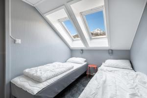 two beds in a room with two windows at Hemsedal Cafe Skiers Lodge in Hemsedal