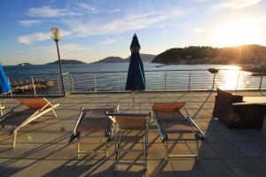 a deck with chairs and an umbrella and the ocean at Hotel San Terenzo in Lerici