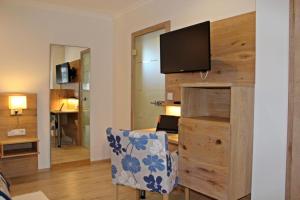 a room with a desk with a television on a wall at Hotel Falkenseer Hof in Falkensee