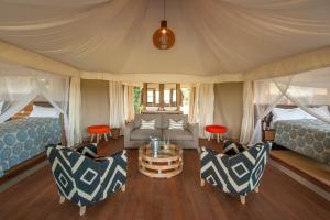 a room with two beds and a table and chairs at Chikunto Safari Lodge in Kakumbi
