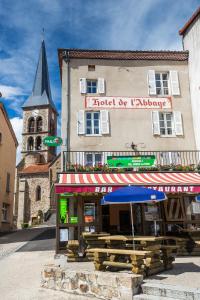 a building with a umbrella and a building with a clock tower at Hotel De L'Abbaye in Sauxillanges