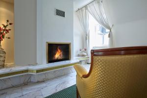 a living room with a fireplace and a chair at Hotel Beek by Anna in Baden-Baden
