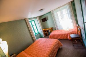 Postel nebo postele na pokoji v ubytování Hotel De L'Abbaye