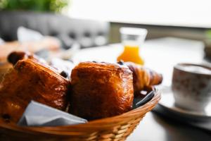 a basket of bread and pastries on a table at Hostellerie LE PANEL in Mandelieu-La Napoule