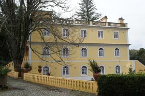 uma casa amarela com uma cerca em frente em Quinta Do Convento em Vila Verde dos Francos