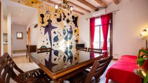 a dining room with a table with a cross on the wall at Apartamentos El Pintor in Barcelona