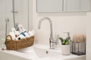 un lavandino in bagno con un cesto di asciugamani di HolySuite Even Israel a Gerusalemme Altre 79 foto