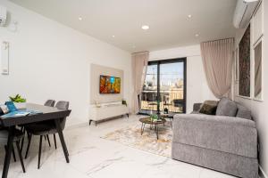 un soggiorno con divano, tavolo e scrivania di HolySuite Even Israel a Gerusalemme