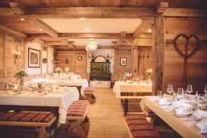 a dining room with tables with white tablecloths at Almhütten Moselebauer in Klippitztorl