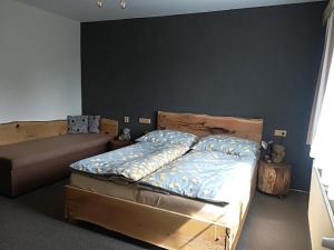 - une chambre avec un lit et un canapé dans l'établissement Apartmány Dana, à Horní Branná