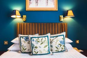 ロンドンにあるロンドン ロッジ ホテルのベッドルーム1室(青い壁、枕付きのベッド1台付)