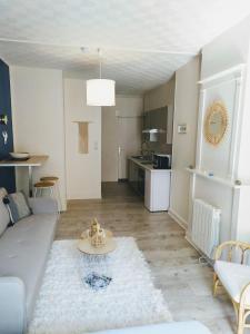a living room with a couch and a table at 2 Emplacement Parfait ! 150m de la mer et de la rue Piétonne in Dieppe +14 photos