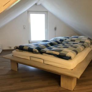 a bed sitting on a wooden bench in a room at Alte Schlosserei Leistadt in Bad Dürkheim