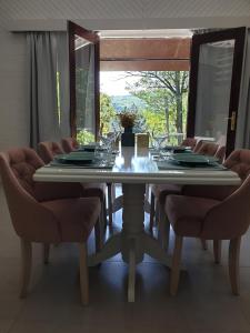 a dining room table with chairs and a large window at Agape Glamping in Velika Remeta