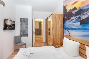 a bedroom with a bed and a painting on the wall at FIRST Wellentraum in Ostseebad Sellin +17 photos
