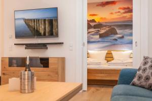 a living room with a television on a wall at FIRST Wellentraum in Ostseebad Sellin