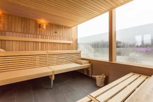 un sauna avec deux bancs et une grande fenêtre dans l'établissement FIRST Wellentraum, à Sellin