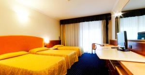a hotel room with two beds and a flat screen tv at Eurocongressi Hotel in Cavaion Veronese