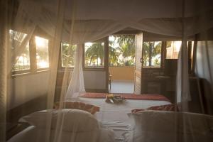 伊塔卡雷的住宿－特克塞度假酒店，一间卧室,床上放着鲜花