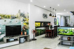 F.Home Modern & Art 3BR Near My Khe Beach في دا نانغ: غرفة معيشة مع تلفزيون كبير وحوض أسماك