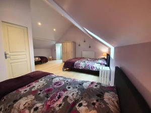 a attic bedroom with two beds and a door at le coq du morvan in Bussières