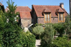 ein altes Backsteinhaus mit Fenstern und Bäumen in der Unterkunft La Vigne du Pont in Vieux-Château