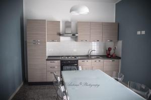 a kitchen with wooden cabinets and a white table at Il Tamburino Lucio in San Gemini