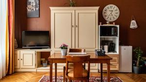 a living room with a table and a clock on the wall at La Villa in Rouen