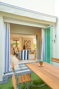 a patio with a wooden table and a living room at Charming Coastal Townhouse at The Majestic in Kalk Bay