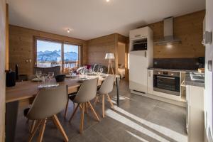 a kitchen and dining room with a table and chairs at ODYSSEE ARC02 Appartement sur les pistes avec vue panoramique in La Toussuire