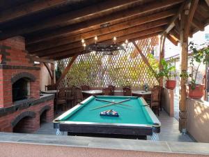 a patio with a pool table and a fireplace at Villa Magnat in Berehove