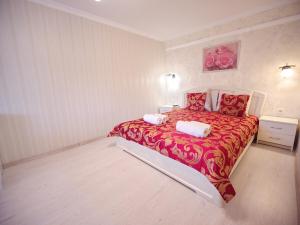 a bedroom with a large red bed with two pillows at Villa Magnat in Berehove