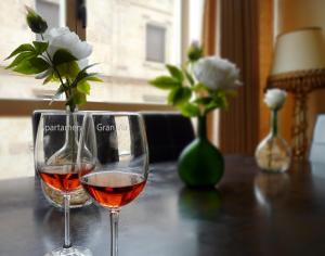 een glas wijn zittend op een tafel met bloemen bij Apartamentos Gran Via in Salamanca