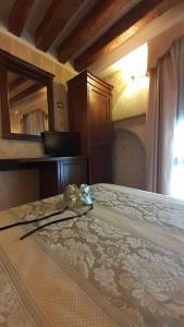 een slaapkamer met een bed, een dressoir en een spiegel bij Locanda Barbarigo in Venetië